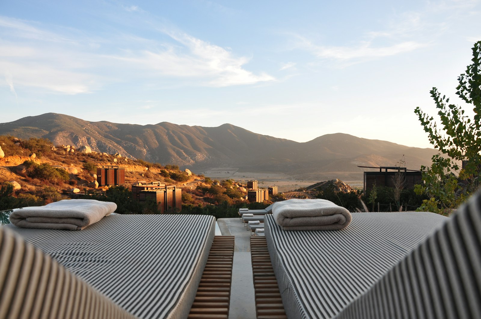 Sun loungers overlooking a mountain resort at dusk
