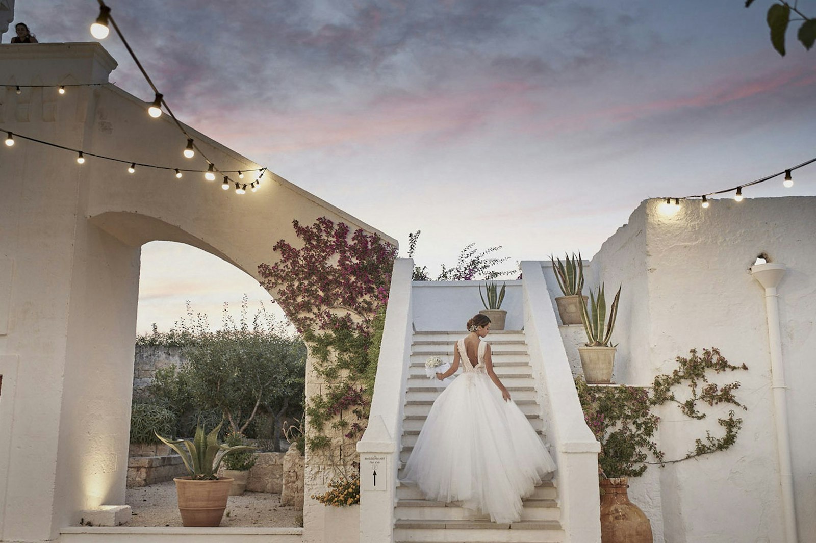 A bride descending a stone staircase at dusk