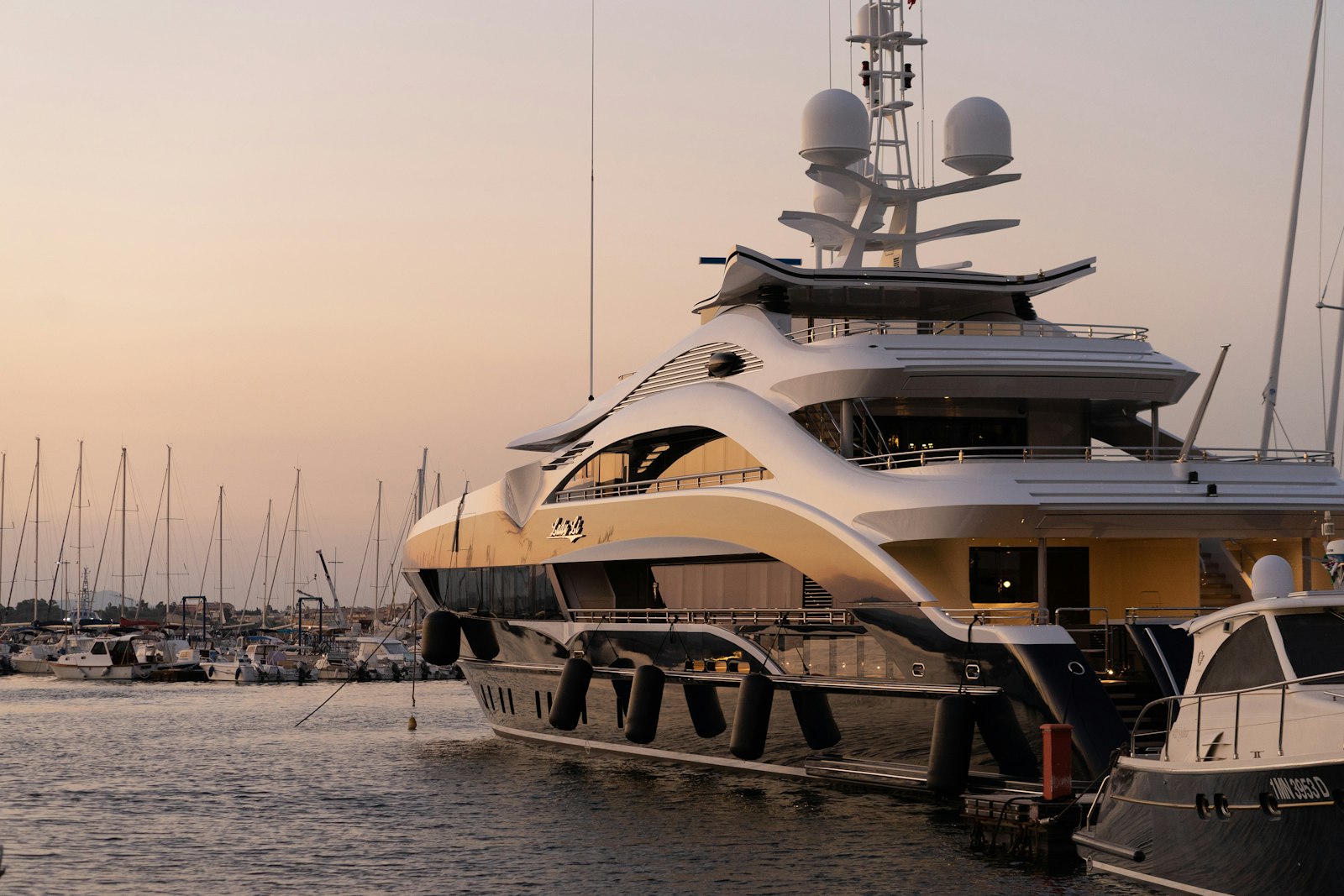 A superyacht moored at a marina at golden hour
