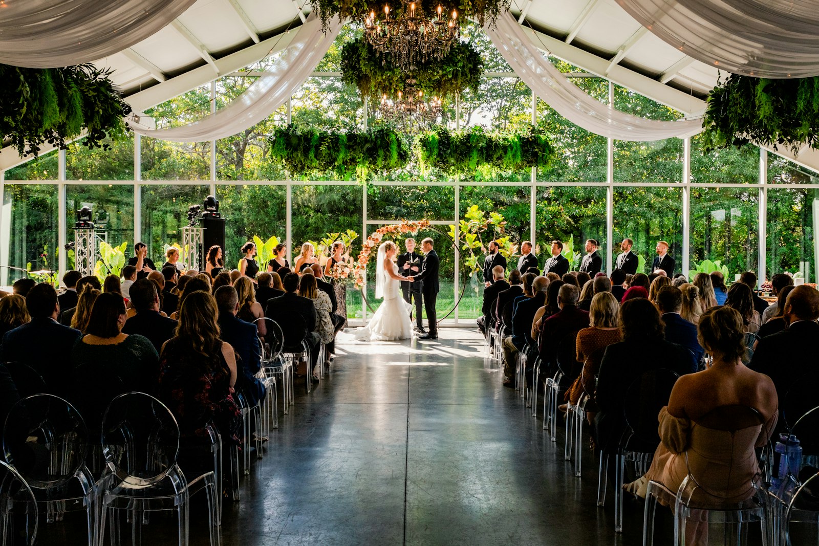 A bride and groom at the altar of a glass-walled ceremony venue